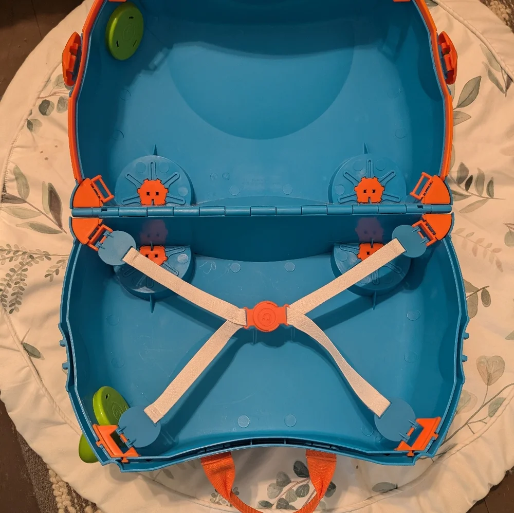 Melissa & Doug blue ride-on Trunki with green wheels and orange handle